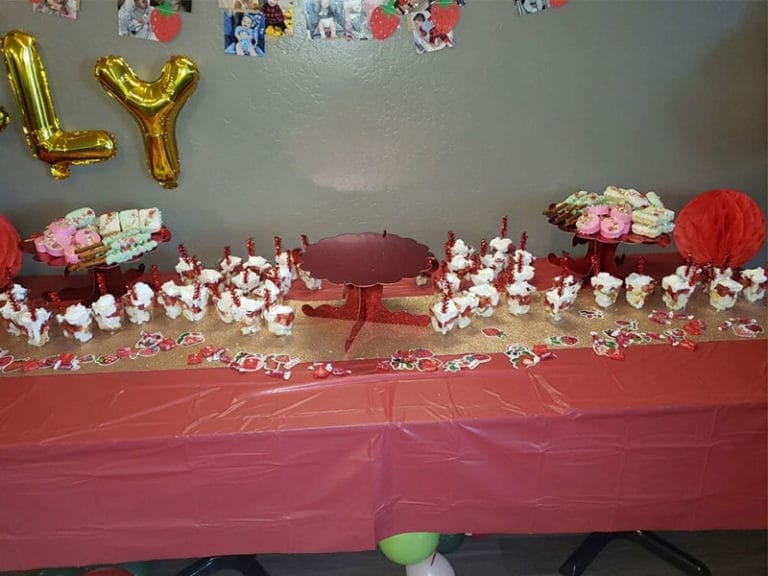 A festive table with red cupcakes and balloons, perfect for a birthday party.