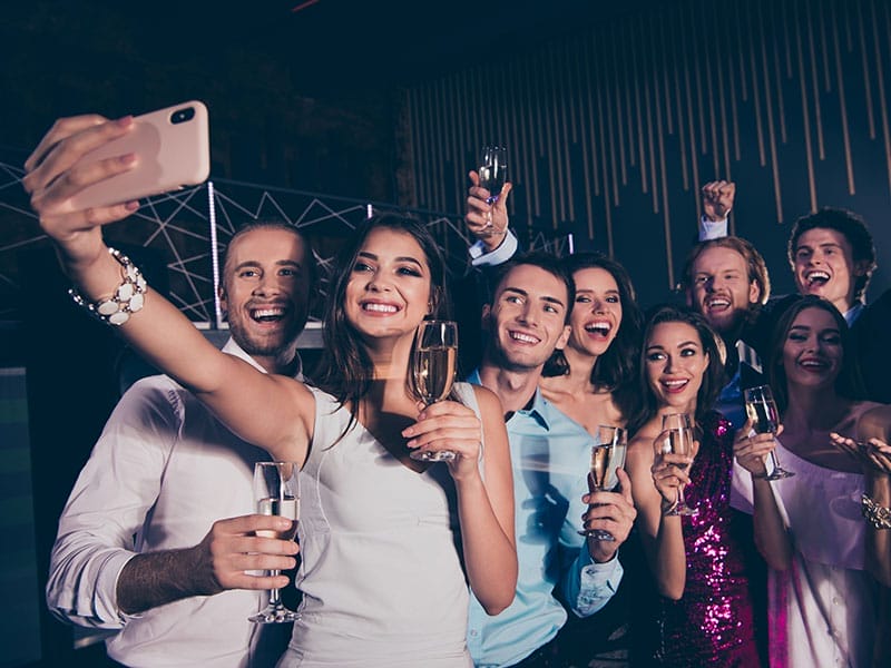 A group of people taking a selfie at a party.