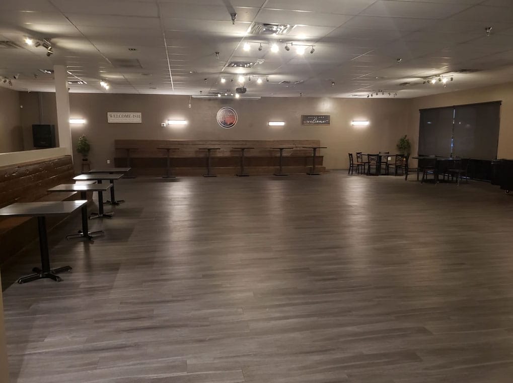 An empty event space in Tempe with tables and chairs, ready for you to rent.