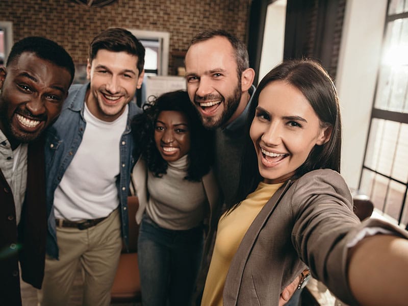 A group of people taking a selfie in an office.