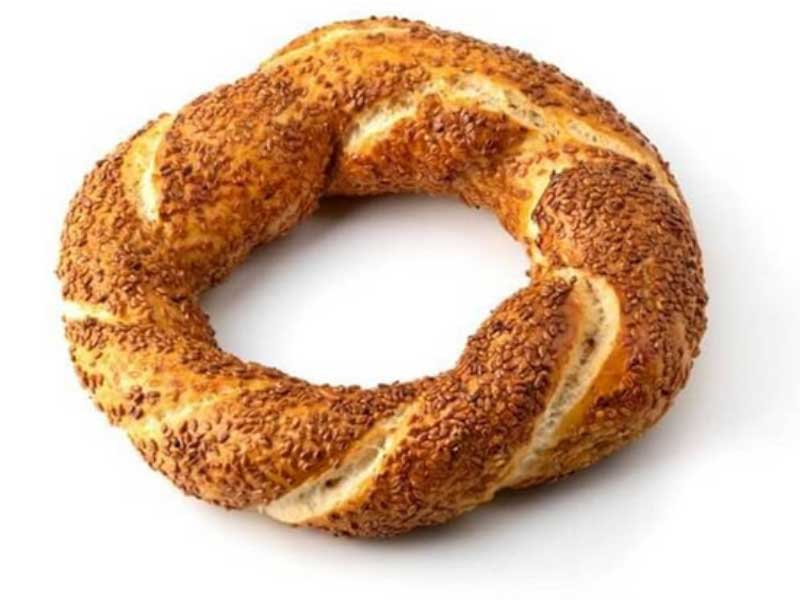 A turkish bagel, koulouri also known as Simit, with sesame seeds on a white background.